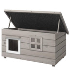Grey wooden cat house with asphalt roof and two front windows, elevated legs