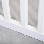 White wooden pet gate base with vertical bars and support rail on the floor