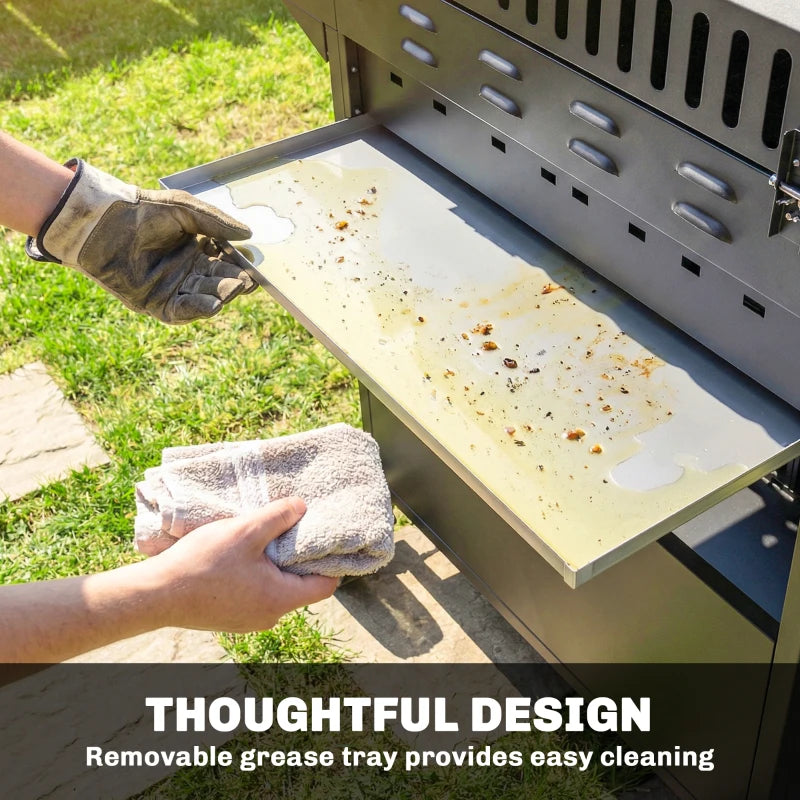 Black grill with removable grease tray being wiped clean with a cloth