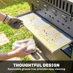 Black grill with removable grease tray being wiped clean with a cloth