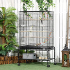 Black bird cage on wheels with shelf, food containers, and hanging toys