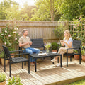 Black patio seating set with slatted loveseat, two chairs, and coffee table in garden.