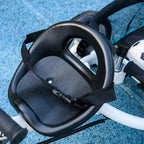 Blue kids trike stroller seat with black safety harness and padded support