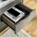 Grey nightstand with open drawer, holding books and a smartphone