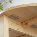 Close-up of natural wood drop-leaf hinge and metal support under the tabletop