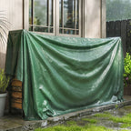 Green waterproof PE tarpaulin cover draped over equipment near a building