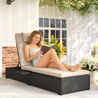 Black rattan reclining sun lounger with beige cushion, used for reading