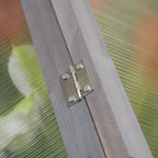 Metal hinge on grey wooden cold frame greenhouse frame
