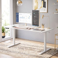White adjustable standing desk with computer setup and open underside clearance