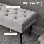 Grey tufted bench cushion with thick padding and dark legs, corner view