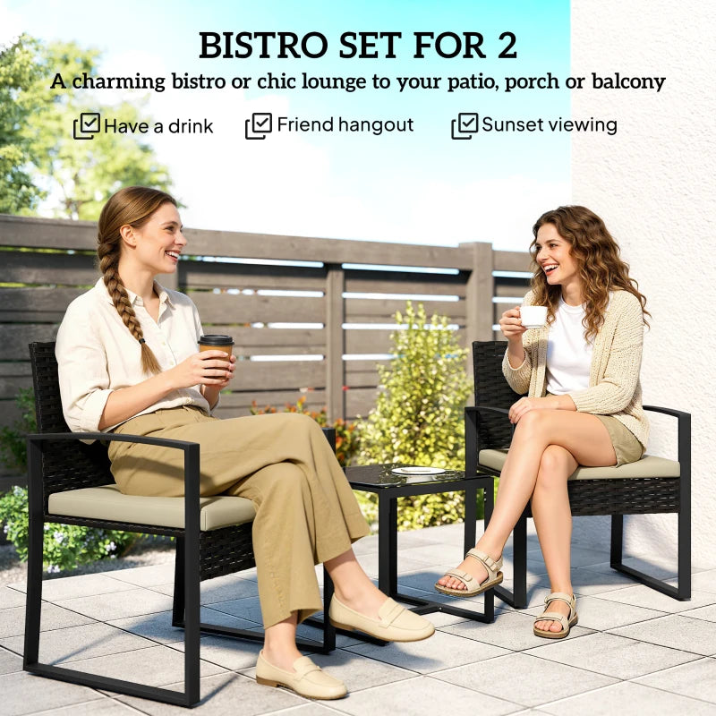 Rattan bistro set for 2 with two dark wicker chairs and tan seat cushions, glass table