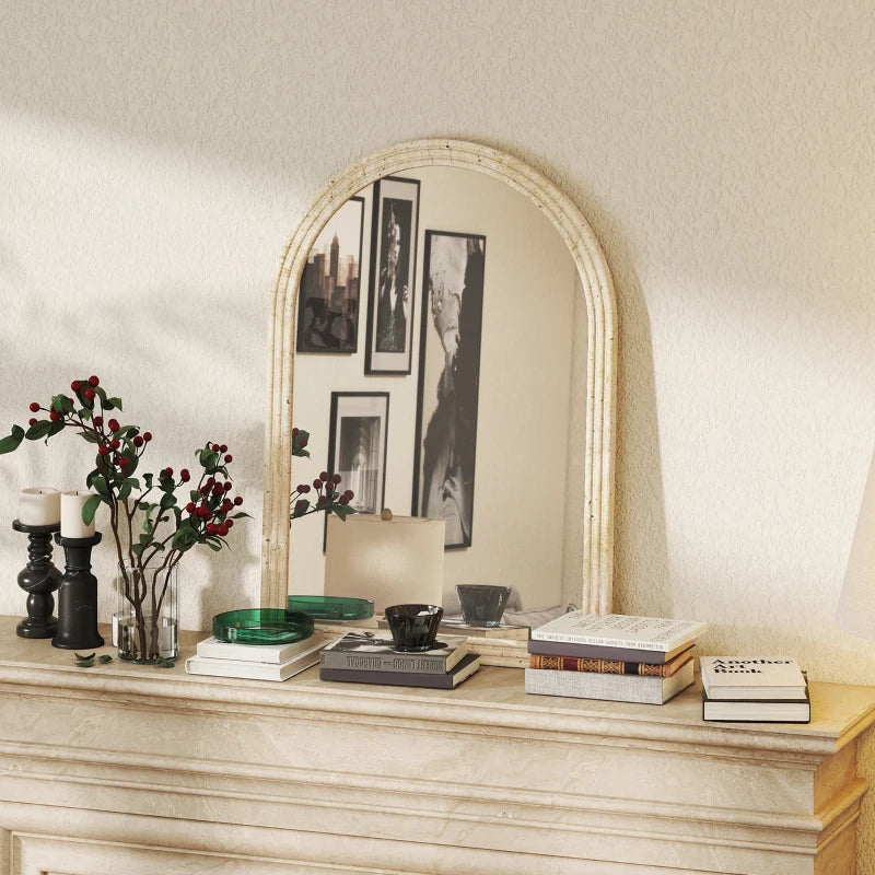 Beige arched wall mirror with textured grooved frame on a decorative shelf