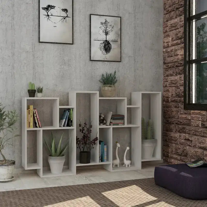 Tall modern display bookcase with open cubby shelves, white finish, styled with plants