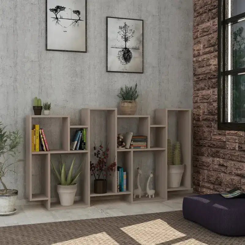 Tall modern display bookcase with open cubby shelves, light gray/white finish, styled with plants