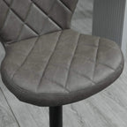 Close-up of dark grey diamond tufted bar stool seat with stitched edges and round base