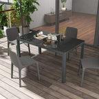Grey glass-top dining table with aluminium legs and seating around it