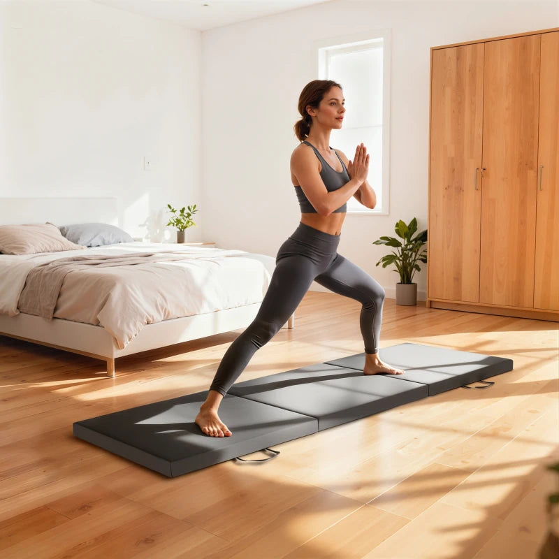 Grey tri-fold workout mat with carrying strap handles, used for lunges