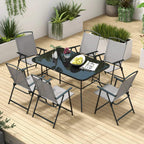 Grey glass-top outdoor dining table with folding chairs, seven-piece set