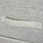 Close-up of grey linen drawer front with fabric texture and light handle