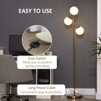 Gold three-light floor lamp with three round globe shades and long power cable