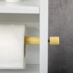 White bathroom cabinet door with gold knob handle beside paper storage