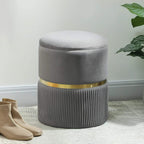 Grey storage ottoman with round cushioned lid, ribbed sides, and gold-tone accent band