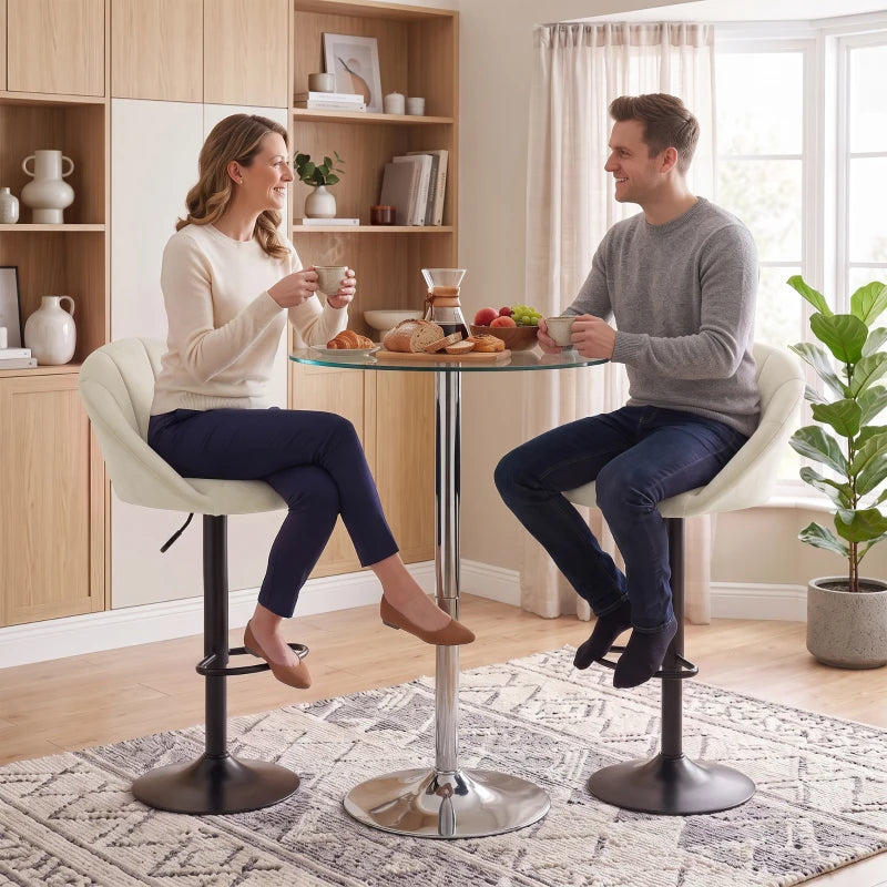 Cream upholstered counter stool with curved back, black base, and footrest