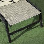 Grey woven seat surface on black legs of a foldable rattan-look sun lounger