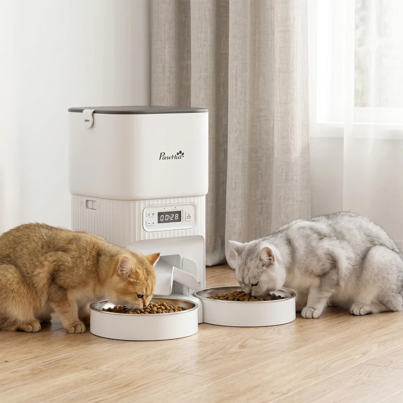White automatic cat feeder with dual stainless bowls feeding a tabby and gray cat