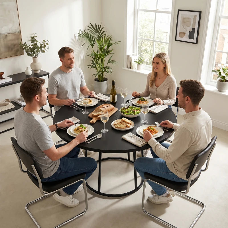 Round black dining table with central conical metal base surrounded by chairs