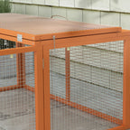 Orange rabbit hutch corner close-up with wire mesh walls and top bars.