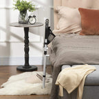 Installed safety bed rail with white frame and black grab handle beside bed