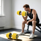 Adjustable yellow dumbbells with stacked plates and black handle, person exercising on bench