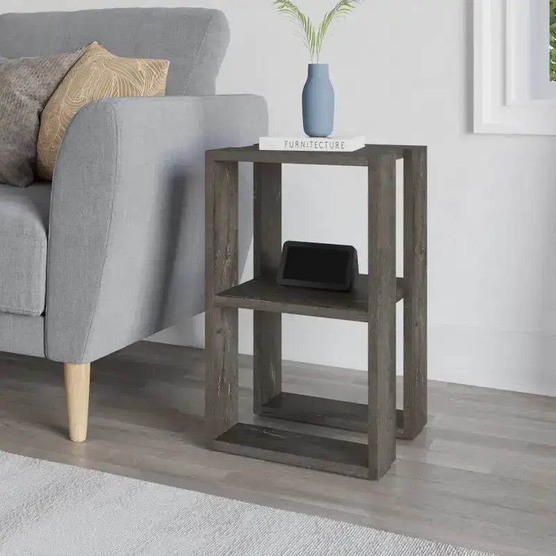 Modern bedside table with open shelves, dark wood-look finish, styled with blue vase