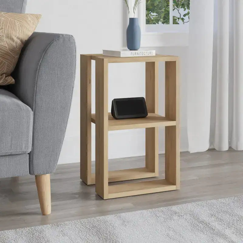 Modern bedside table with open shelves, light oak finish, styled with black electronics