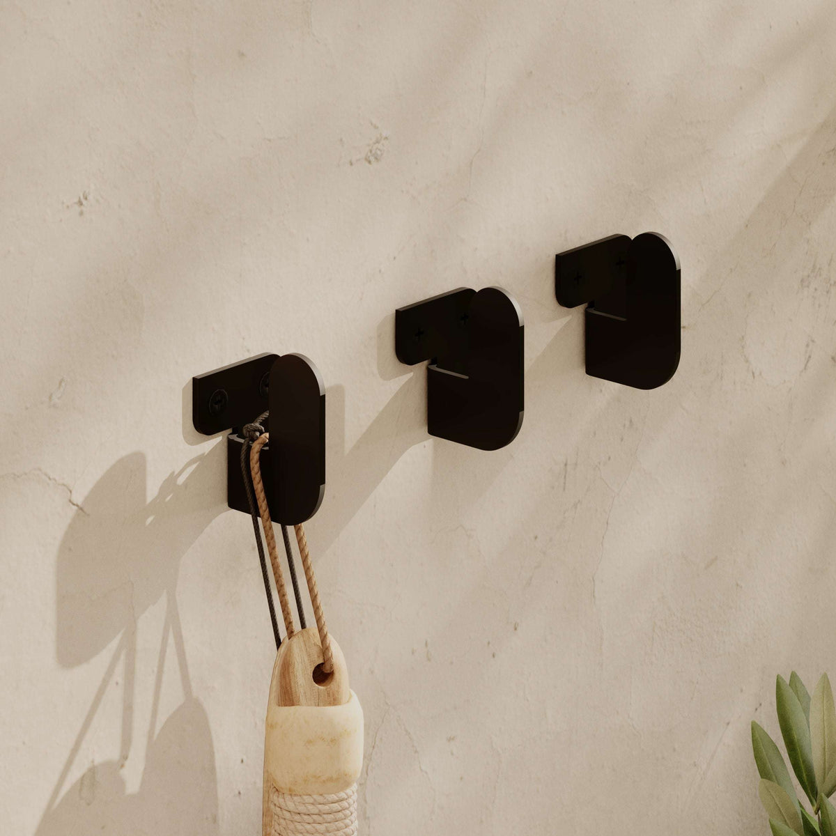 Black metal hook hanger set with three square backplates and curved hooks