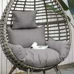 Close-up of grey cushions on wicker egg chair with woven teardrop backrest