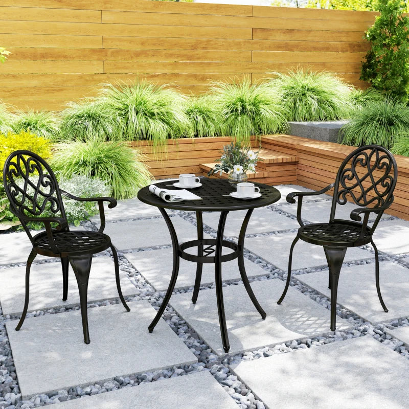 Black three-piece bistro set with round table and two scroll-back chairs on patio