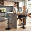 Green swivel bar stool with curved upholstered seat, footrest ring, and round base