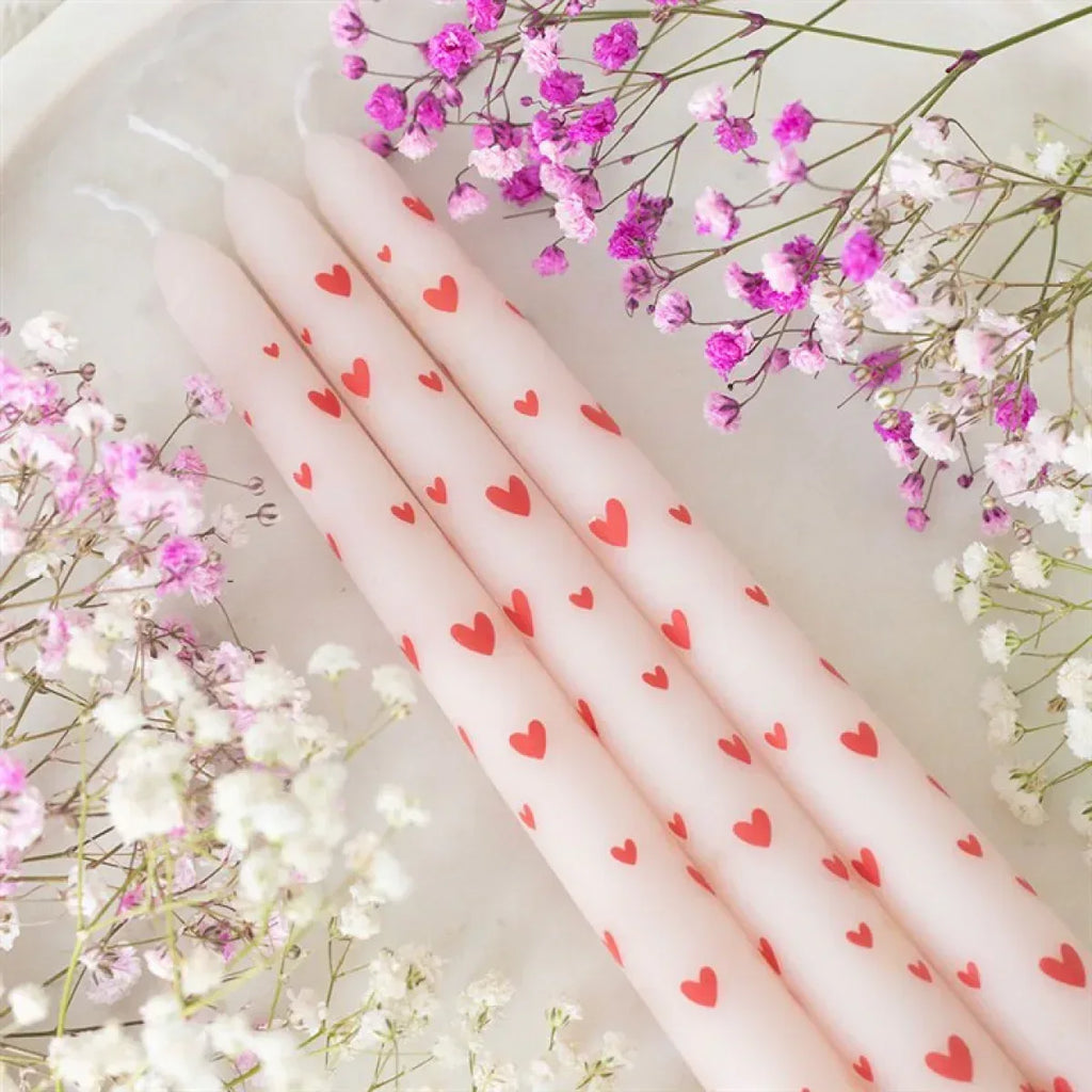 Set of three pink taper candles with red heart pattern
