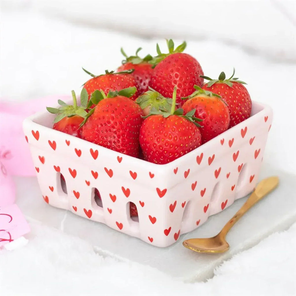 Pink ceramic berry basket with red heart print, holds fresh strawberries