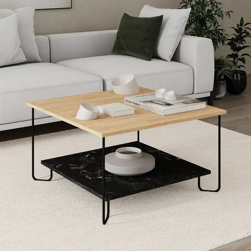 Coffee table with light oak top and black lower shelf on black metal legs.