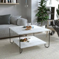 Modern square coffee table with white top, black metal legs, and lower shelf.