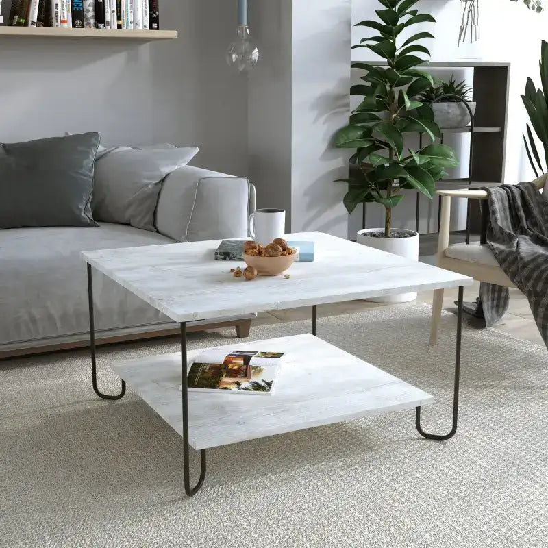 Modern square coffee table with white top, black metal legs, and lower shelf.