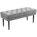 Grey velvet bed end bench with button-tufted top and dark tapered legs