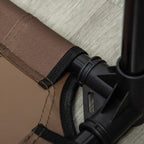 Corner strap and black leg joint detail on a brown elevated dog cot