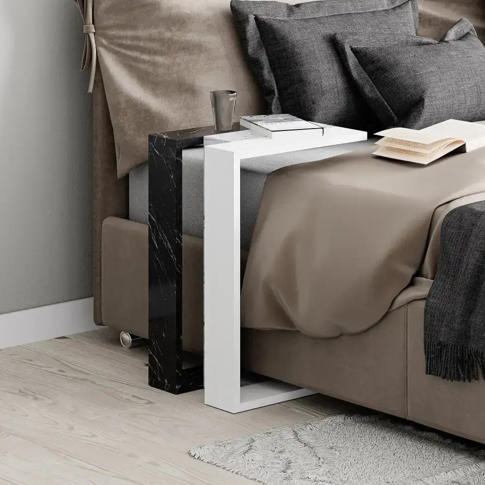 C-shaped side table with dark marble panel and white frame, placed beside seating