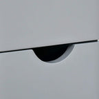 Grey cabinet drawer with curved black handle pull.