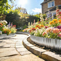Silver corrugated steel edging border curved around a paved walkway next to flowers