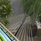 Black hammock stand end supports holding a striped hammock with rope straps